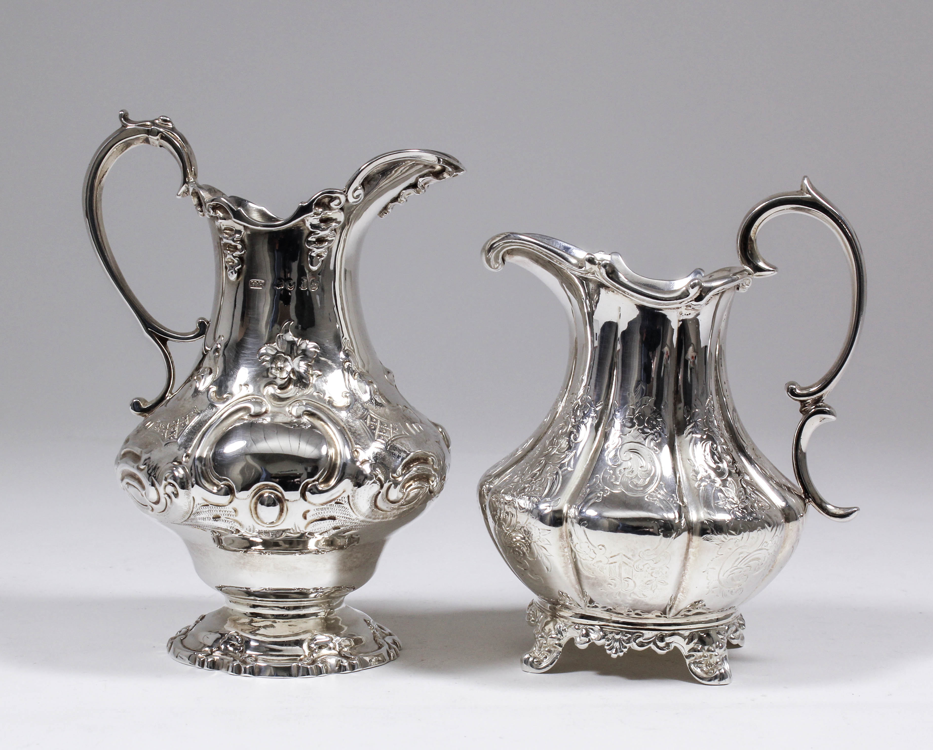 Two Victorian silver bulbous milk jugs with shaped rims and double scroll handle, one with low