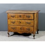 An 18th Century North Italian walnut commode, the quarter veneered top with shaped central panel