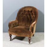 A Victorian spoon back easy chair upholstered in brown dralon, the back buttoned, on turned front