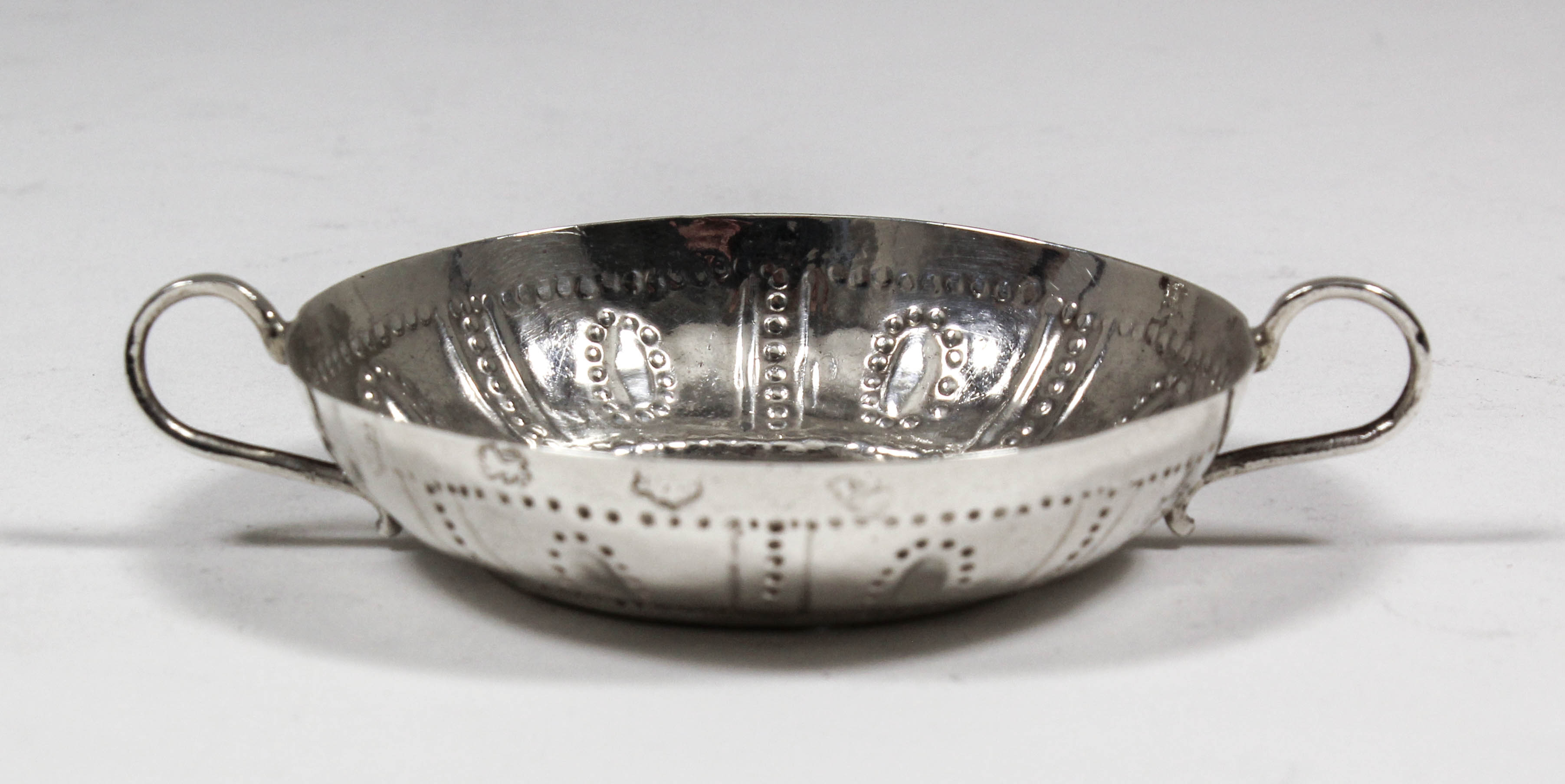 A rare Commonwealth silver circular two-handled taste-vin, the shallow bowl with punched