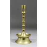 A 15th Century copper alloy candlestick, the shaft with four discoid knops above a shallow cone