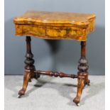 A Victorian figured walnut games table of serpentine outline, the quarter veneered folding top