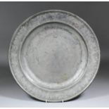 A large 18th Century pewter charger, the rim stamped "ED", the back with "London" and further