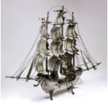 A Continental Alpaca silvery metal model of a galleon complete with three masts and figures on