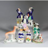 A small collection of English Staffordshire pottery figures, including - Piper with dog beside a