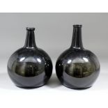 A pair of large late 18th Century glass bottles of dark olive tint, 10ins high and 10.25ins high