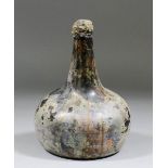 An early 18th Century Dutch onion shaped glass bottle with original waxed stopper and contents, 7ins