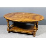 A modern oak oval drop leaf coffee table with flush panel to top, on baluster turned legs and turned