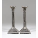 A pair of George V silver pillar candlesticks with cast Corinthian capitols and stop fluted columns,