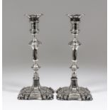 A pair of George V silver pillar candlesticks of mid 18th Century design, with moulded leaf capped