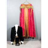 An ecclesiastical vestment in red patterned silk with gold braiding, and matching cape with