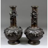 A pair of late 19th Century Japanese bronze bottle shaped vases, the bodies cast with birds