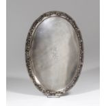 An Edward VII silver oval dressing table tray, the border cast with ribbon and floral swags, 12.5ins