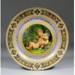 A "Vienna" porcelain charger, the centre painted with cupid, a child and a puppy, within a raised