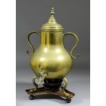An 18th Century Dutch two-handled brass urn and lid with tap, on three legs, with copper stand and