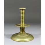 A brass candlestick, the rib shaft with central drip tray above a shallow trumpet base, English, 7.