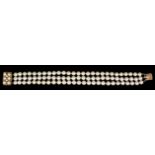 A modern 9ct gold and cultured pearl three strand bracelet with pearl set rectangular clasp, 190mm