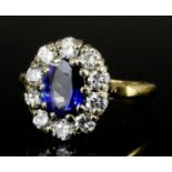 A modern 18ct gold mounted sapphire and diamond ring, the central oval cut sapphire approximately