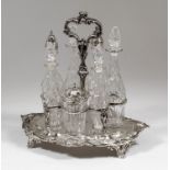 A Victorian silver oval seven division cruet stand with cast leaf scroll capped loop centre