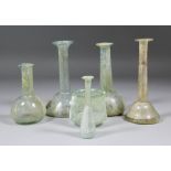 A late Roman glass Unguentarium, 6.75ins high, four others, 4.5ins to 6.75ins high, and a Roman