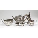 An Edward VII silver oval three piece tea service with part reeded bodies and angular loop