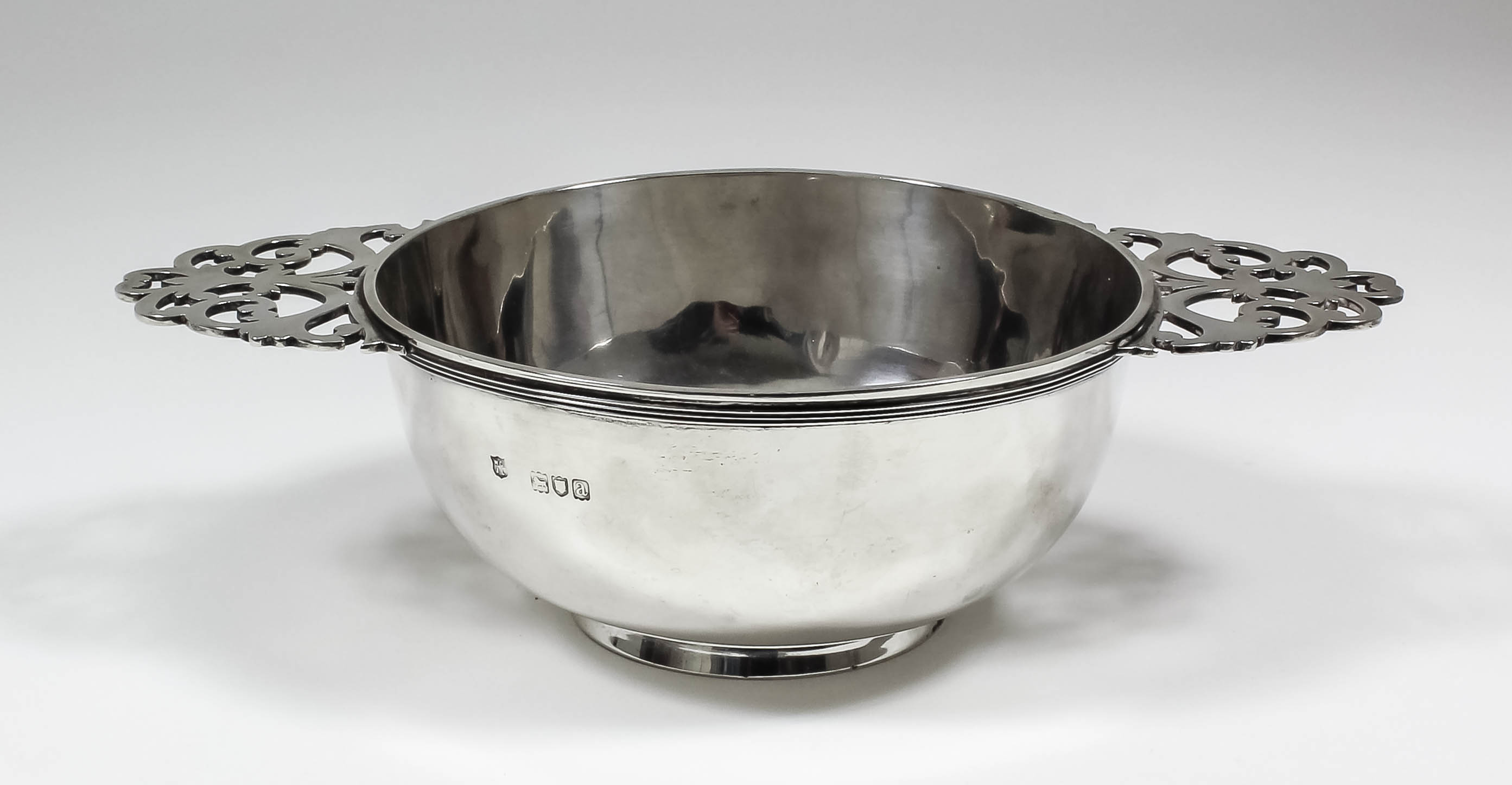 A late Victorian silver circular two-handled quaich with moulded rim and pierced handles, 5.75ins