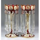 A pair of 19th Century Bohemian ruby and white overlay glass lustre candlesticks with shaped rims,