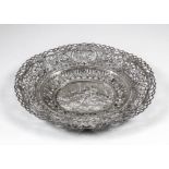 A Continental silvery metal oval basket, the whole pierced and embossed with Putti in a landscape,