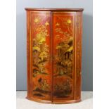 An 18th Century red japanned bow front hanging corner cupboard, decorated in gilt with chinoiseries,