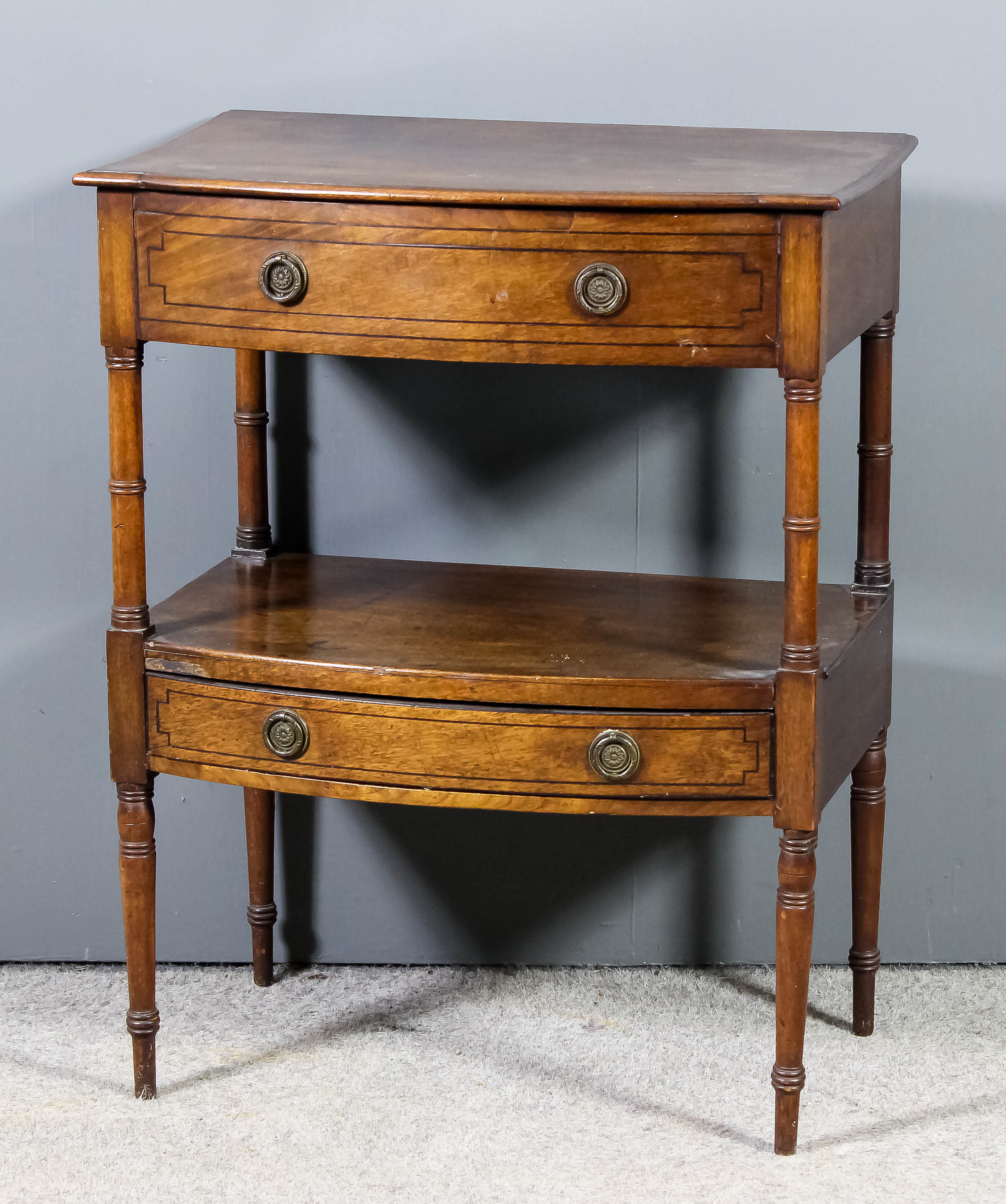 A late Georgian mahogany bow front two tier side table with moulded edge to top, fitted one dummy