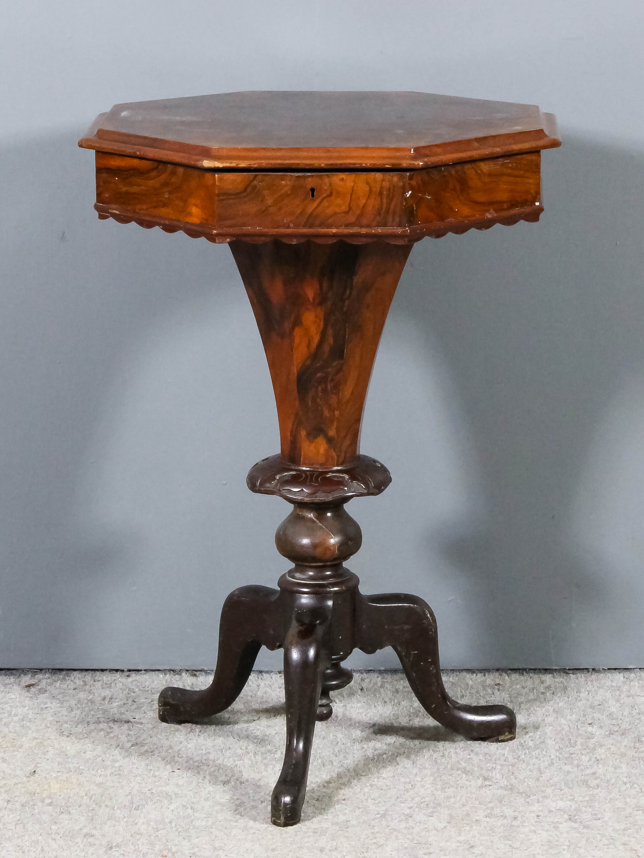 A Victorian figured walnut octagonal work table, the lifting top opening to reveal fitted