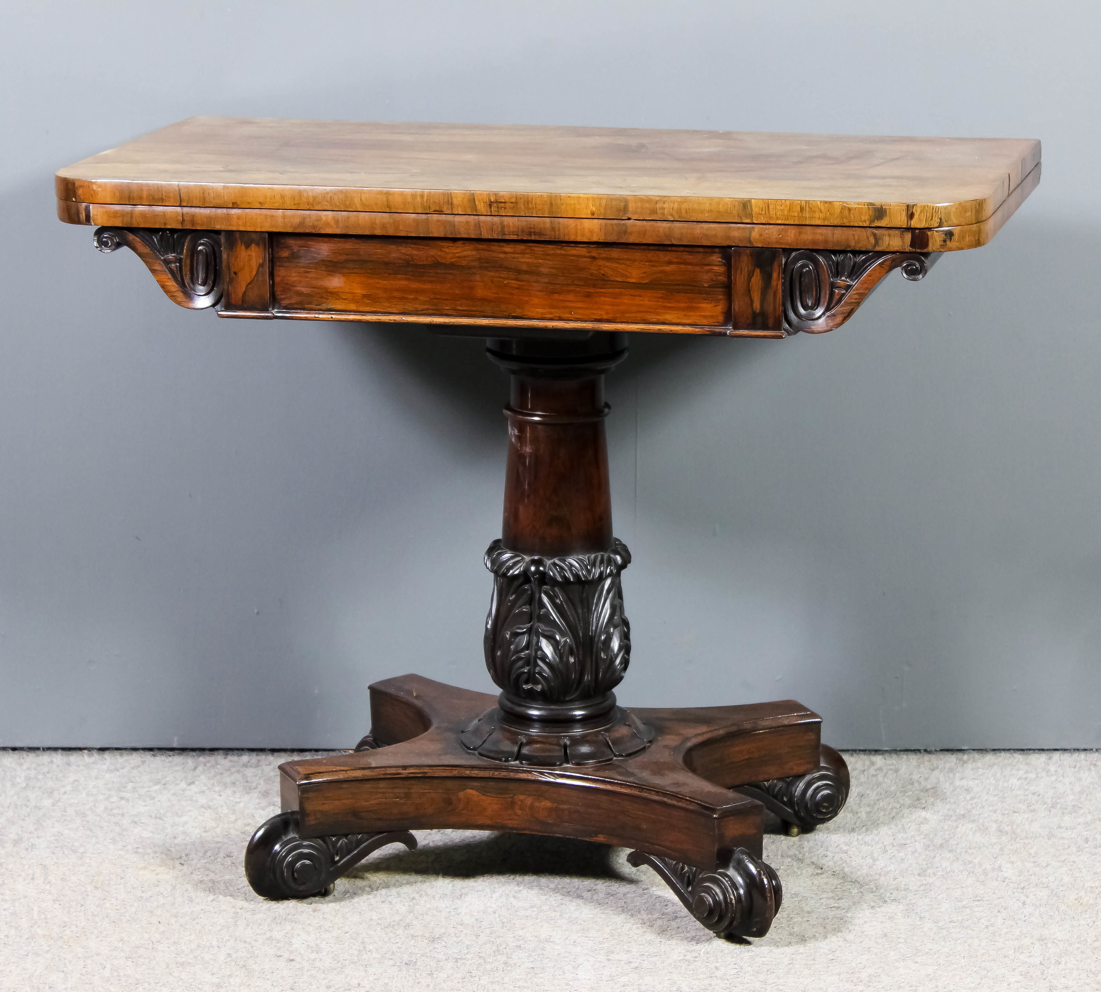 An early Victorian rosewood rectangular card table, with plain baize lined folding top, scroll