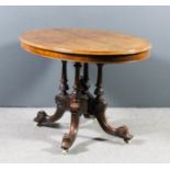 A Victorian walnut oval breakfast table with quarter veneered burr top, on four turned and fluted