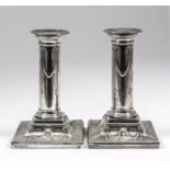 A pair of late Victorian silver pillar candlesticks of Neo-classical design with bead mounts, ribbon