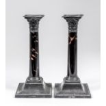 A pair of George V silver and tortoise-shell pillar candlesticks with cast Corinthian capitols,