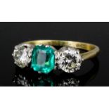 A modern gold and silvery coloured metal mounted emerald and diamond three stone ring, the square