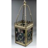 A late 19th Century pressed brass hall lantern, the four sides with geometric stained glass