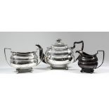 A George III silver rectangular three-piece tea service, with bead mounts, the bulbous bodies