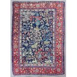 A Tabriz rug woven in colours with numerous trees, birds and animals, on a navy blue ground,