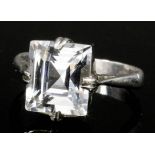 An early 20th Century silvery coloured metal mounted white sapphire ring, the emerald cut stone of