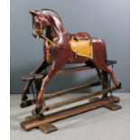 An early 20th Century brown painted rocking horse on pine base, 56ins long x 18ins deep x 48ins