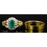 A modern 18ct gold mounted emerald and diamond ring, the central oval cut emerald of approximately