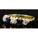 A modern 18k sapphire and diamond five stone ring set with two sapphires and three brilliant cut