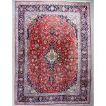 A good Kashan carpet woven in colours with a central floral filled medallion and conforming