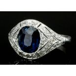 A silvery coloured metal mounted sapphire and diamond ring in the "Art Deco" manner, the oval cut