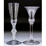 An 18th Century wine glass with plain bell-shaped bowl and stem, the foot with turned-over rim and