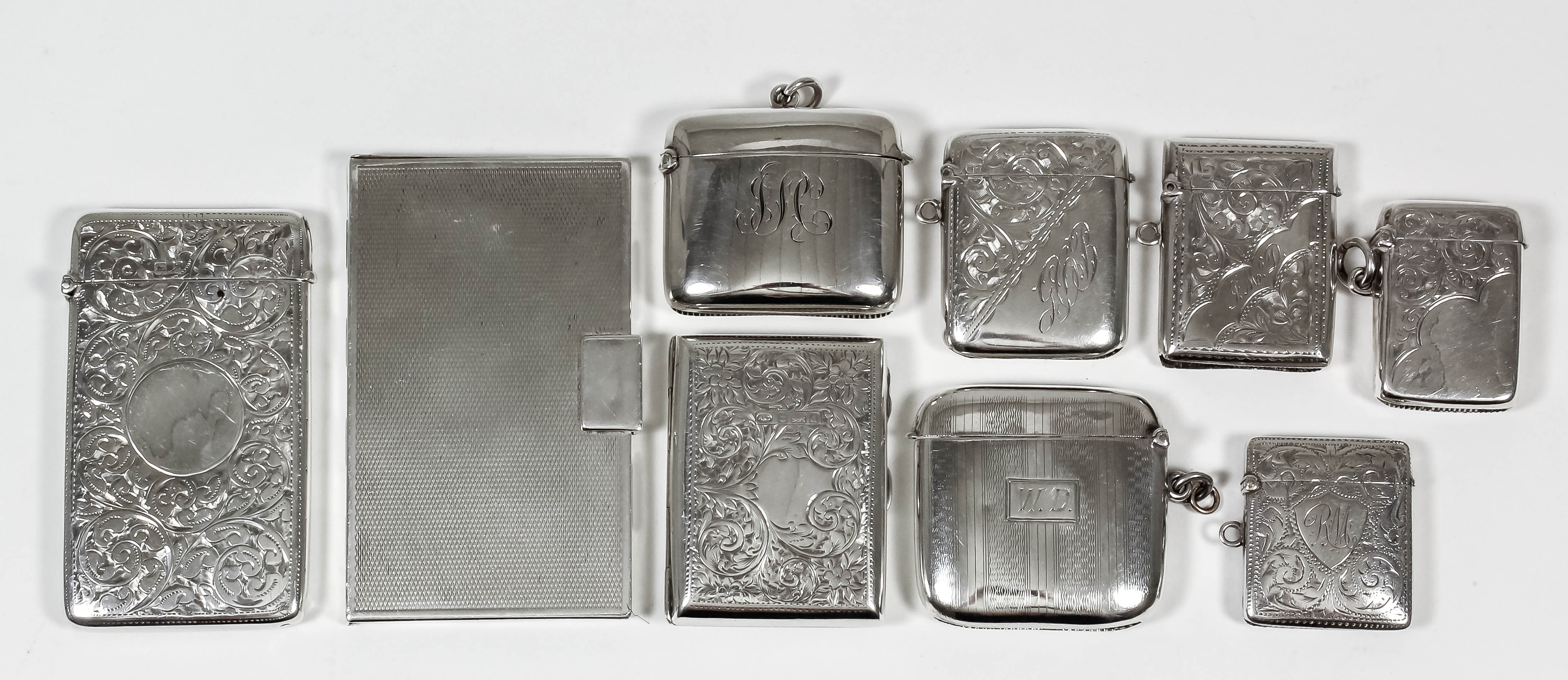 An Edward VII silver rectangular card case engraved with circular cartouche and leaf scroll