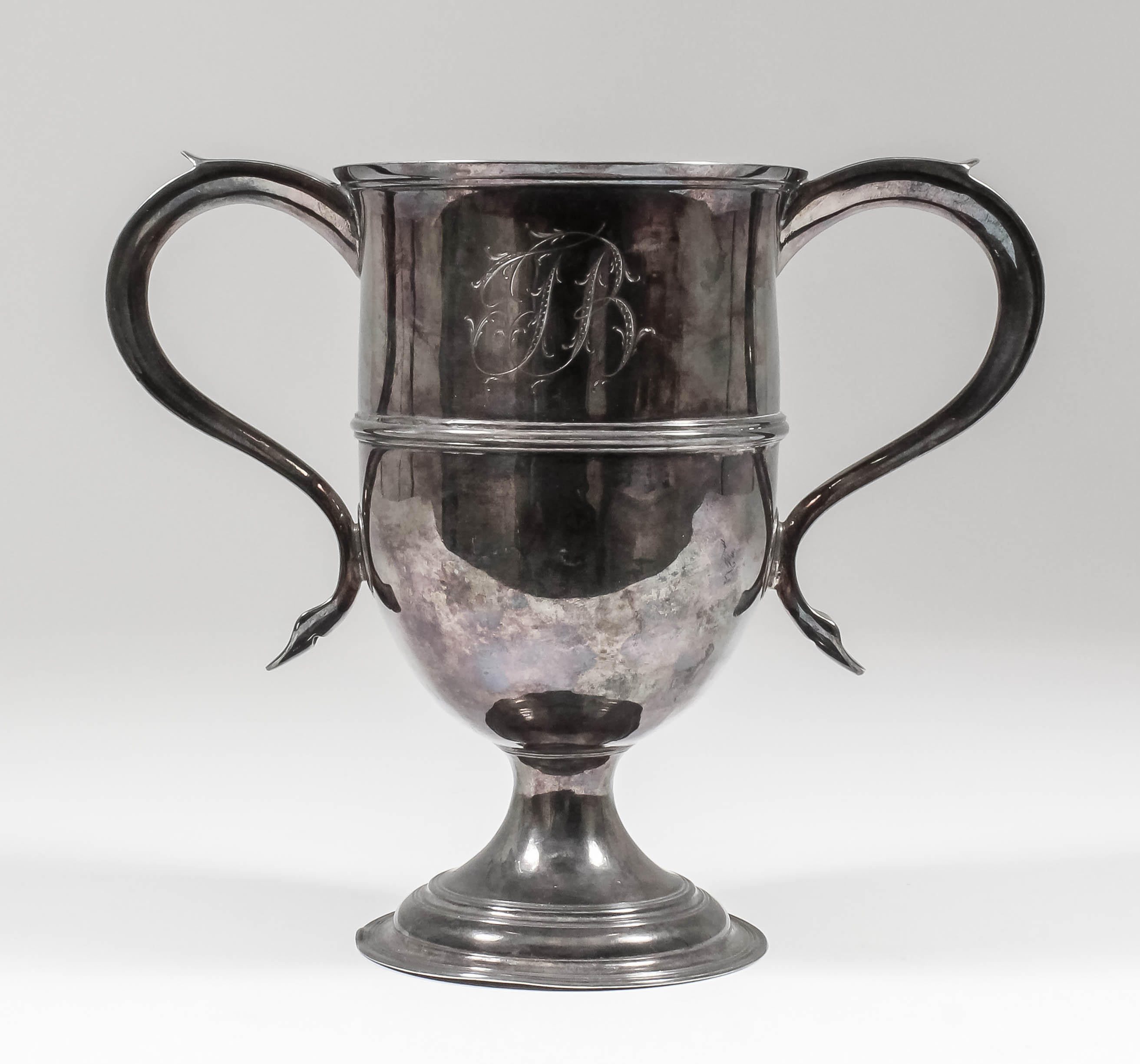 @A George III silver two-handled urn pattern cup with moulded rim and girdle, with s-scroll