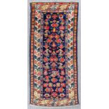 An antique Kuba rug woven in colours in colours with numerous stylized floral motifs, on a navy blue