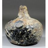 An early 18th Century glass sealed "onion" shaped wine bottle of dark green tint, the seal with